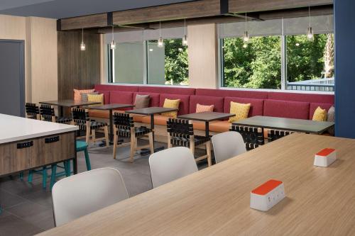 a restaurant with tables and chairs and a red couch at Tru By Hilton Charleston Ashley Phosphate, Sc in Charleston