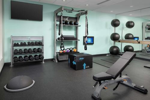 a room with a gym with a chair and weights at Tru By Hilton Charleston Ashley Phosphate, Sc in Charleston