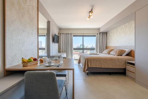 a bedroom with a bed and a table with fruit on it at LIV - Apartamento 1011 in Porto Alegre