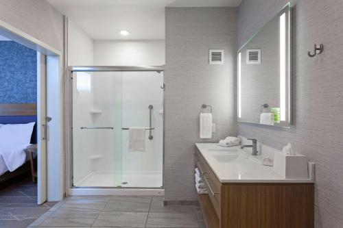 La salle de bains est pourvue d'une douche, d'un lavabo et d'un miroir. dans l'établissement Home2 Suites By Hilton Temecula, à Temecula