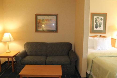 a hotel room with a couch and a bed at Days Inn & Suites by Wyndham Bridgeport - Clarksburg in Bridgeport