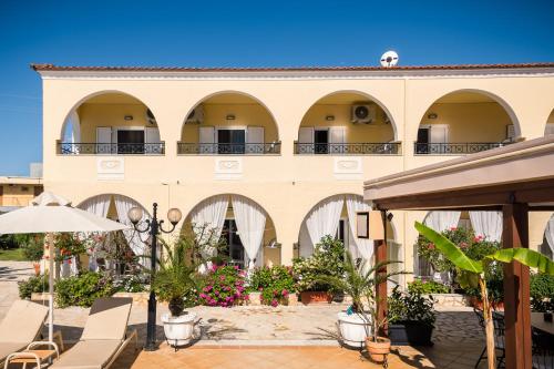 a building with arches and plants in front of it at Konstantina Apartments in Kavos