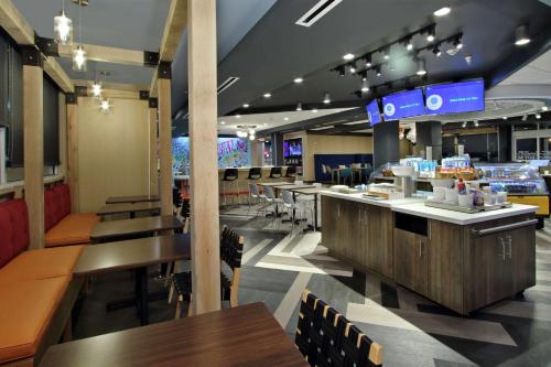 restauracja ze stołami i krzesłami oraz bar w obiekcie Tru by Hilton Bryan College Station w mieście Bryan