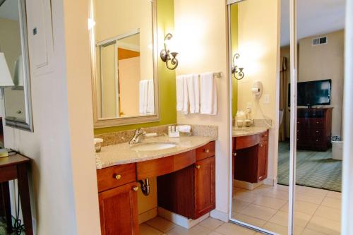 a bathroom with two sinks and a shower at Homewood Suites by Hilton College Station in College Station