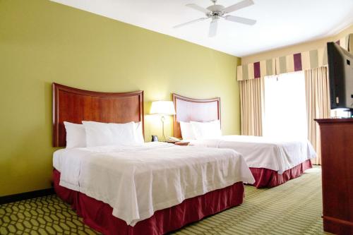 a hotel room with two beds and a flat screen tv at Homewood Suites by Hilton College Station in College Station