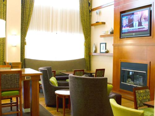a waiting room with chairs and a fireplace at Hampton Inn & Suites College Station in College Station