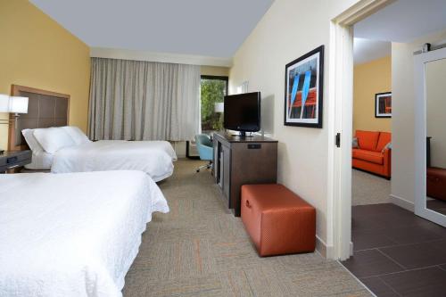 a hotel room with two beds and a flat screen tv at Hampton Inn Charlotte North Lake Norman in Cornelius