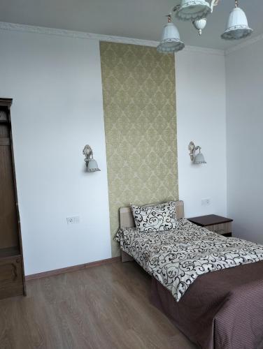 a bedroom with a bed and a wall at Вілла Сади Єви in Lyubintsy
