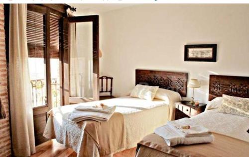 ein Hotelzimmer mit 2 Betten und einem Fenster in der Unterkunft La hospederia de guadamur in Guadamur