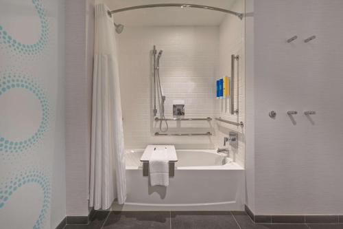 La salle de bains blanche est pourvue d'une baignoire et d'une douche. dans l'établissement Tru By Hilton Mooresville, à Mooresville