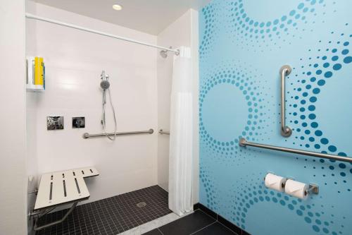 a bathroom with a blue shower stall with a bench at Tru By Hilton Rock Hill, SC in Rock Hill