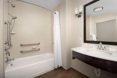 ein Bad mit einer Badewanne, einem Waschbecken und einer Dusche in der Unterkunft Hilton Garden Inn Charlotte Airport in Charlotte