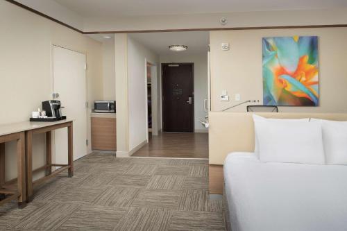 a hotel room with a bed and a kitchen at Hilton Garden Inn Charlotte Airport in Charlotte