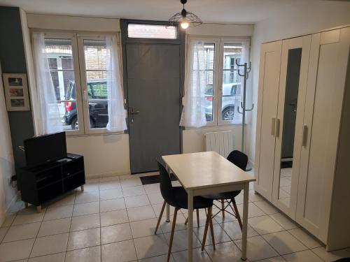 un salon avec une table, des chaises et une télévision dans l'établissement Studio proche Mer et Port de Dieppe, à Dieppe