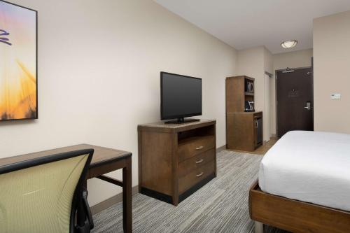a hotel room with a bed and a flat screen tv at Hilton Garden Inn Charlotte Airport in Charlotte