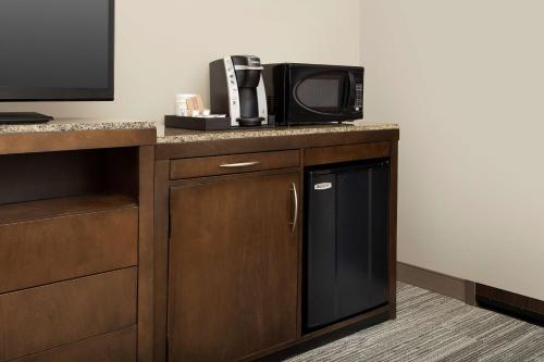a microwave sitting on top of a counter with a tv at Hilton Garden Inn Charlotte Airport in Charlotte