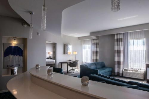 Hampton Inn & Suites Charlotte/Ballantyne, Nc في تشارلوت: غرفة معيشة مع أريكة زرقاء وطاولة