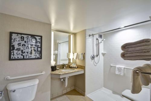 a bathroom with a shower and a toilet and a sink at Embassy Suites Charlotte in Charlotte