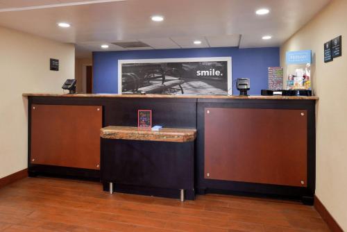 a lobby with a bar with a smile sign on the wall at Hampton Inn Columbus-East in Pickerington