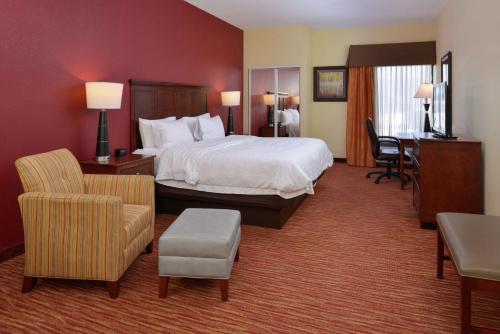 a large hotel room with a bed and chairs at Hampton Inn Columbus-East in Pickerington