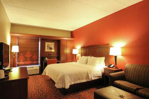 a hotel room with a bed and a couch at Hampton Inn Columbus-South in Grove City
