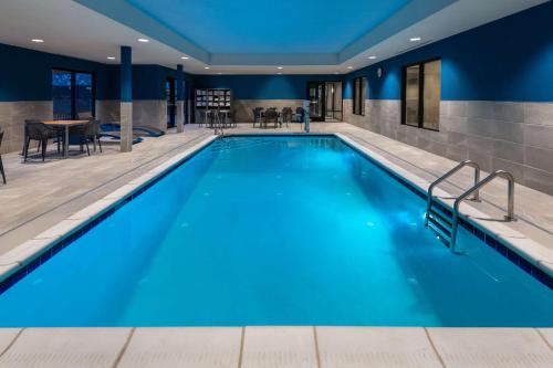 Hampton Inn & Suites Cody, Wy في كودي: حمام سباحة بمياه زرقاء في غرفة في الفندق