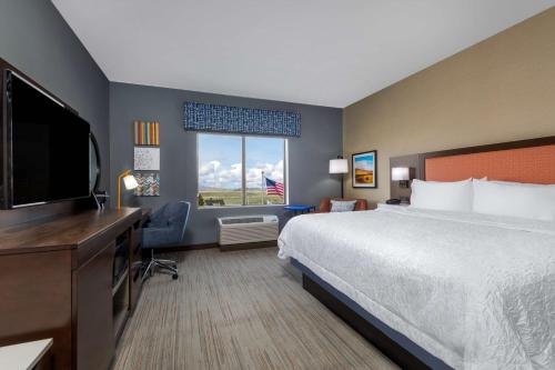 a hotel room with a bed and a flat screen tv at Hampton Inn & Suites Cody, Wy in Cody