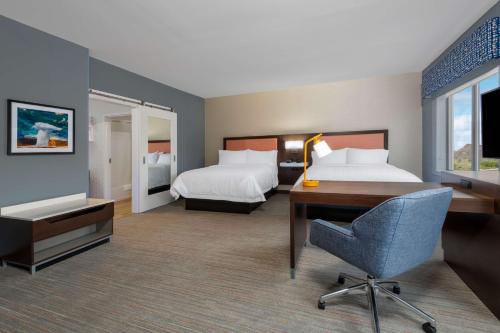 a hotel room with two beds and a desk at Hampton Inn & Suites Cody, Wy in Cody