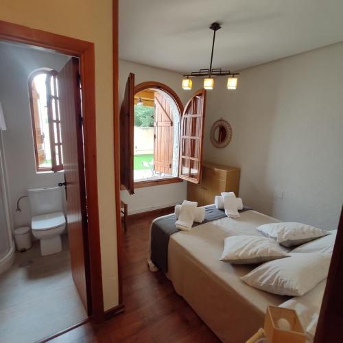 een slaapkamer met 2 bedden en een badkamer met een raam bij EL COBIJO in Mojados