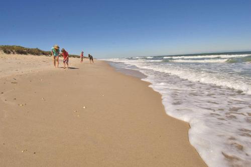 un grupo de personas caminando por la playa en Hampton Inn Cocoa Beach en Cocoa Beach