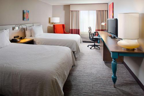 Habitación de hotel con 2 camas y escritorio con ordenador en Hilton Garden Inn Colorado Springs, en Colorado Springs