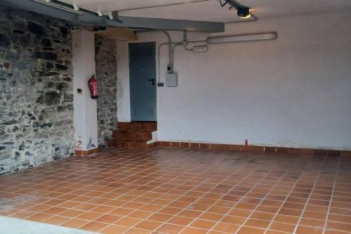 an empty room with a brick wall and a tile floor at Piso con preciosas vistas, patio privado y amplio garaje in Puentedeume