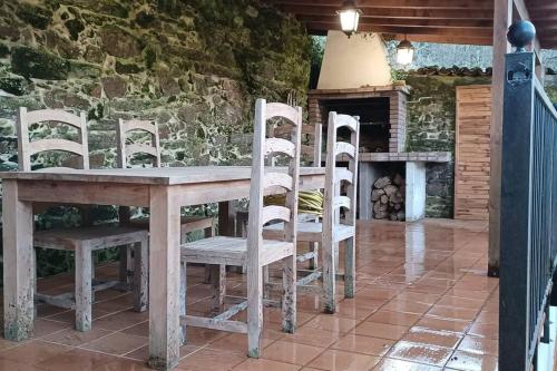 - une table et des chaises dans une pièce dotée d'une cheminée dans l'établissement Piso con preciosas vistas, patio privado y amplio garaje, à Pontedeume