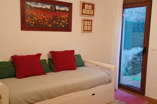 a bed with red and green pillows in a room at Piso con preciosas vistas, patio privado y amplio garaje in Puentedeume