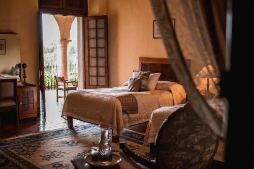 Hacienda El Carmen Hotel & Spa في Portes Gil: غرفة نوم بسرير وكرسي