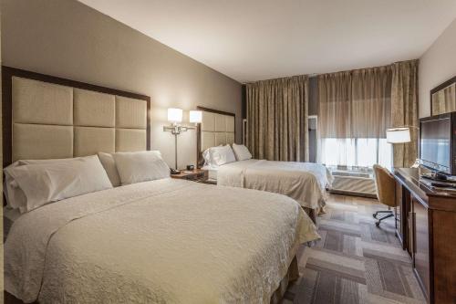 um quarto de hotel com duas camas e uma televisão em Hampton Inn Colorado Springs-Airport em Colorado Springs