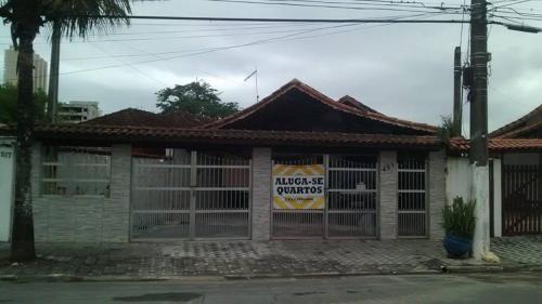 a house with a garage with a sign on it at Hostel do Valdemar in Praia Grande