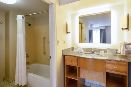 a bathroom with a sink and a tub and a mirror at Homewood Suites by Hilton Colorado Springs-North in Colorado Springs