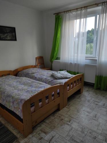 a bedroom with two beds and a window at U lesa in Bohutín