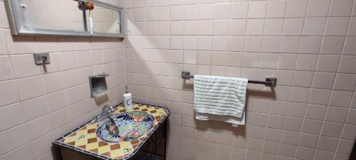 een betegelde badkamer met een wastafel en een handdoek bij Casa hermosa ubicada en el centro in Salina Cruz