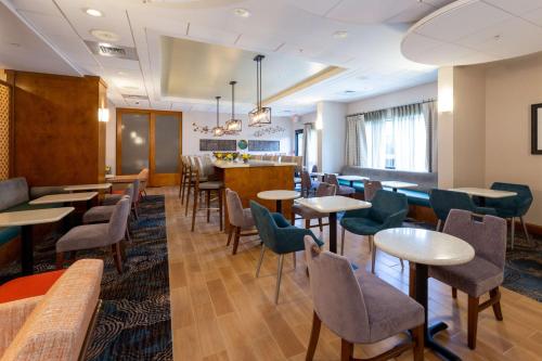 a restaurant with tables and chairs and a bar at Hampton Inn Christiansburg/Blacksburg in Christiansburg