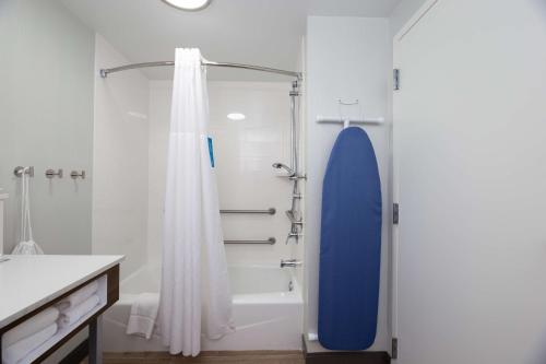 uma casa de banho com um chuveiro e uma prancha de surf azul em Hampton Inn Christiansburg/Blacksburg em Christiansburg