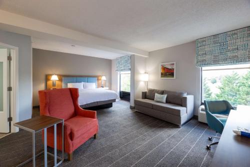 Habitación de hotel con cama, sofá y silla en Hampton Inn Christiansburg/Blacksburg, en Christiansburg