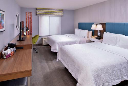 a hotel room with two beds and a desk at Hampton Inn & Suites Carson City in Carson City