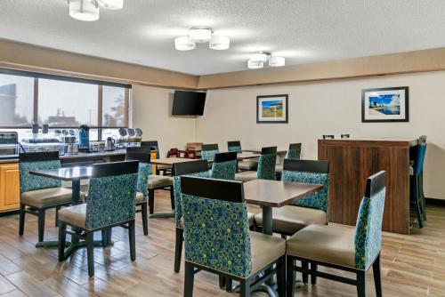 a restaurant with tables and chairs and a bar at Comfort Inn in Manistique