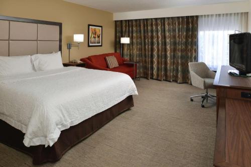 Habitación de hotel con cama y TV en Hampton Inn Carbondale en Carbondale