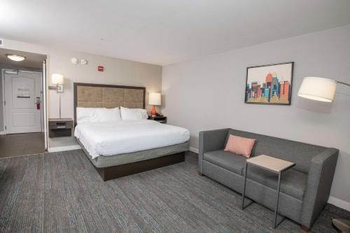 a hotel room with a bed and a couch at Hampton Inn & Suites - Cincinnati/Kenwood, OH in Cincinnati