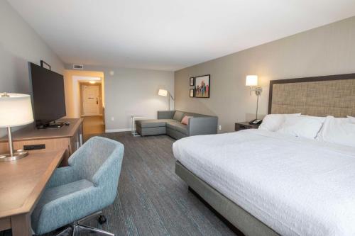 a hotel room with a bed and a couch at Hampton Inn & Suites - Cincinnati/Kenwood, OH in Cincinnati
