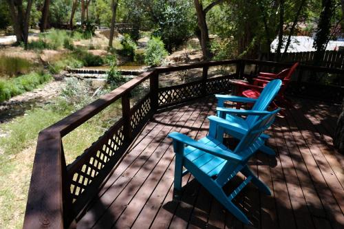 a row of blue chairs on a wooden deck at Creekside Cowa-Bungalow! in Moab