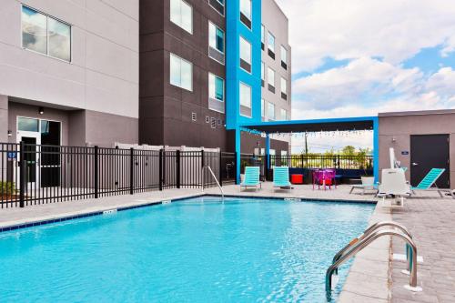 a swimming pool with chairs and a building at Tru by Hilton Auburn in Auburn